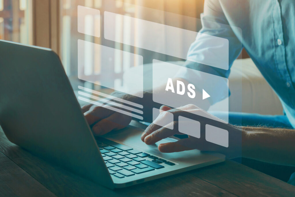 Person using a laptop with digital ad interface overlay, illustrating data-driven Google Ads management and optimization strategies.